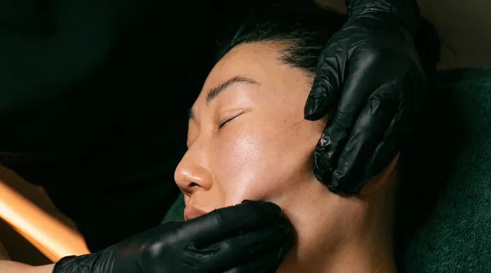 Gloved hands performing buccal massage at the cheek and jaw during a Restorative Buccal Facial at Altru Radiance in Murray, Utah